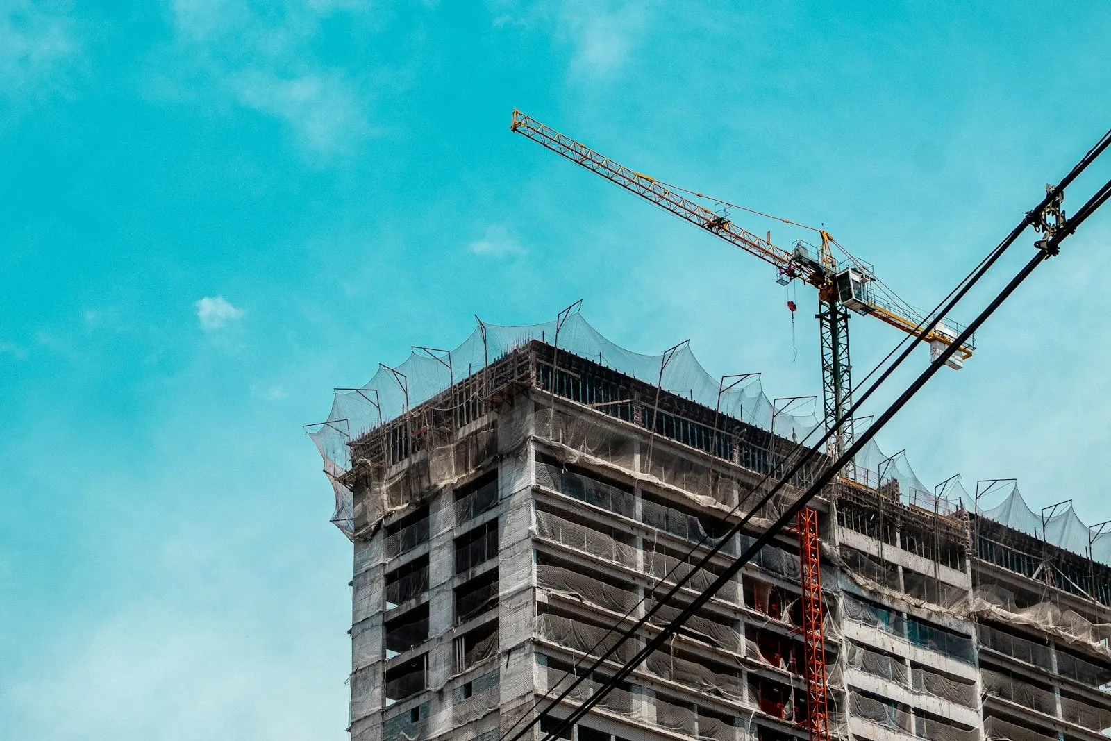 Edificio en construcción con su grúa torre contra el cielo